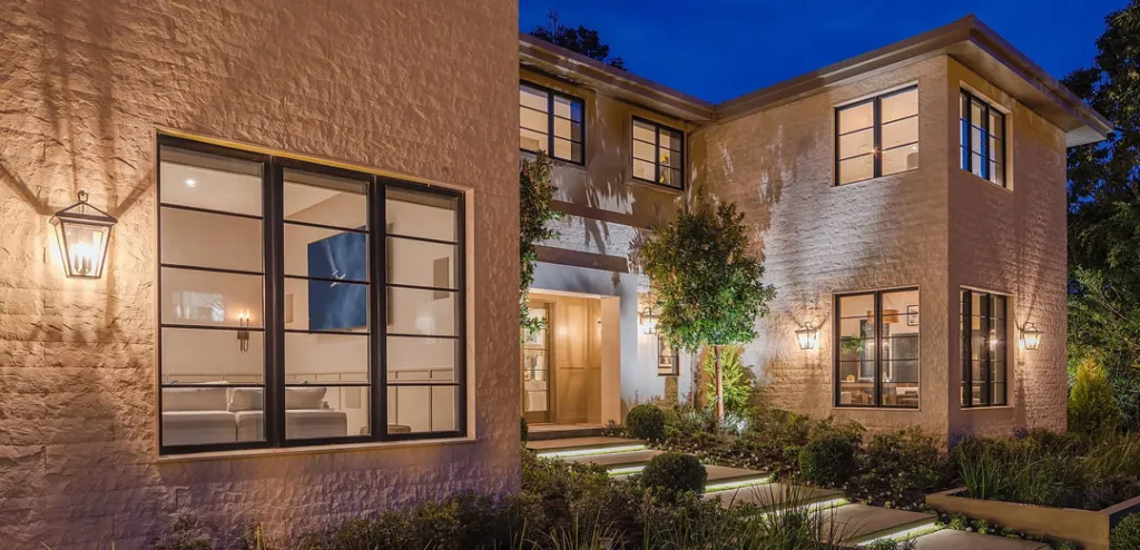 a house with a lot of windows is lit up at night