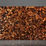 Smooth reflective gemstone countertop surface with intricate mosaic-like patterns in rich warm brown and amber tones.