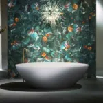 Modern bathroom featuring an oval white bathtub set against an abstract, colorful mosaic wall.