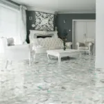 Elegant living room featuring white Victorian furniture, an ornate mantel, soft gray walls, and a polished marble floor.