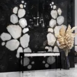 Luxurious interior with a black agate wall featuring white crystals, and a sleek black console table with pampas grass.
