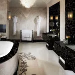 Luxurious bathroom featuring a large white bathtub set in black marble, intricate floor designs, and elegant lighting.
