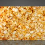 Large illuminated wall panel featuring a textured natural stone mosaic pattern in warm amber and cream tones.