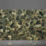 Polished marble slab featuring a reflective mosaic pattern of irregular green, brown, and beige pieces.