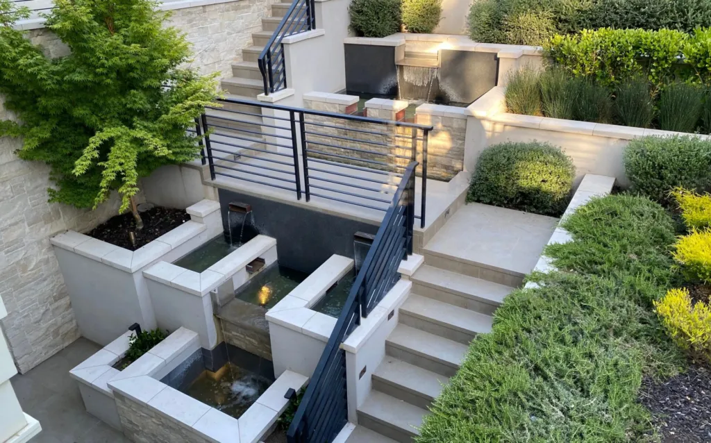 Outdoor Tile - Staircase: A staircase leading up to a fountain with a black railing.
